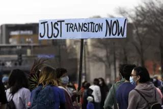 A woman holds a Just Transition Now sign at a rally in Minneapolis, Minnesota
