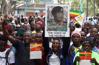 Voice of the people? A man holds up a poster of Zimbabwe Defence Forces chief Constantino Chiwenga at a protest calling for Zimbabwean President Robert Mugabe to resign outside the parliament in Harare.