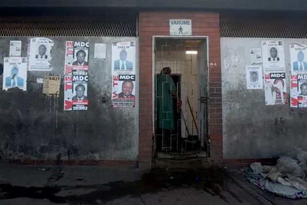 © Nadine Hutton Zimbabean election posters on a grey wall