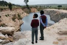 Schoolchildren pass an abandoned mine pit on the outskirts of Wesselton, Ermelo’s satellite township.