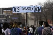 A woman holds a Just Transition Now sign at a rally in Minneapolis, Minnesota
