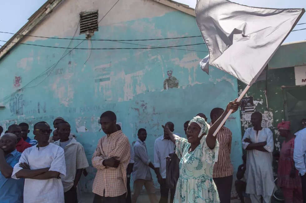 A woman cheers as ECOWAS troops from Senegal gather outside the Gambian statehouse on January 23, 2017 in Banjul.