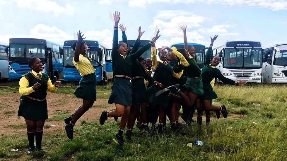 Learners celebrating after buses and taxis arrive at their school.