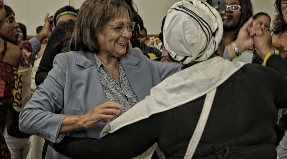 Cape Town Mayor Patricia de Lille dances with women from shelters at a luncheon.