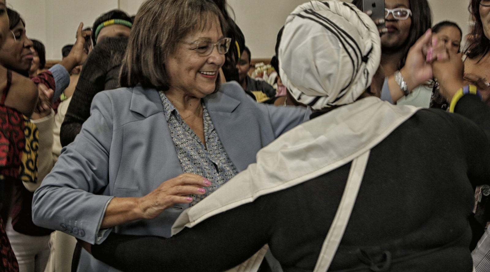 Cape Town Mayor Patricia de Lille dances with women from shelters at a luncheon.